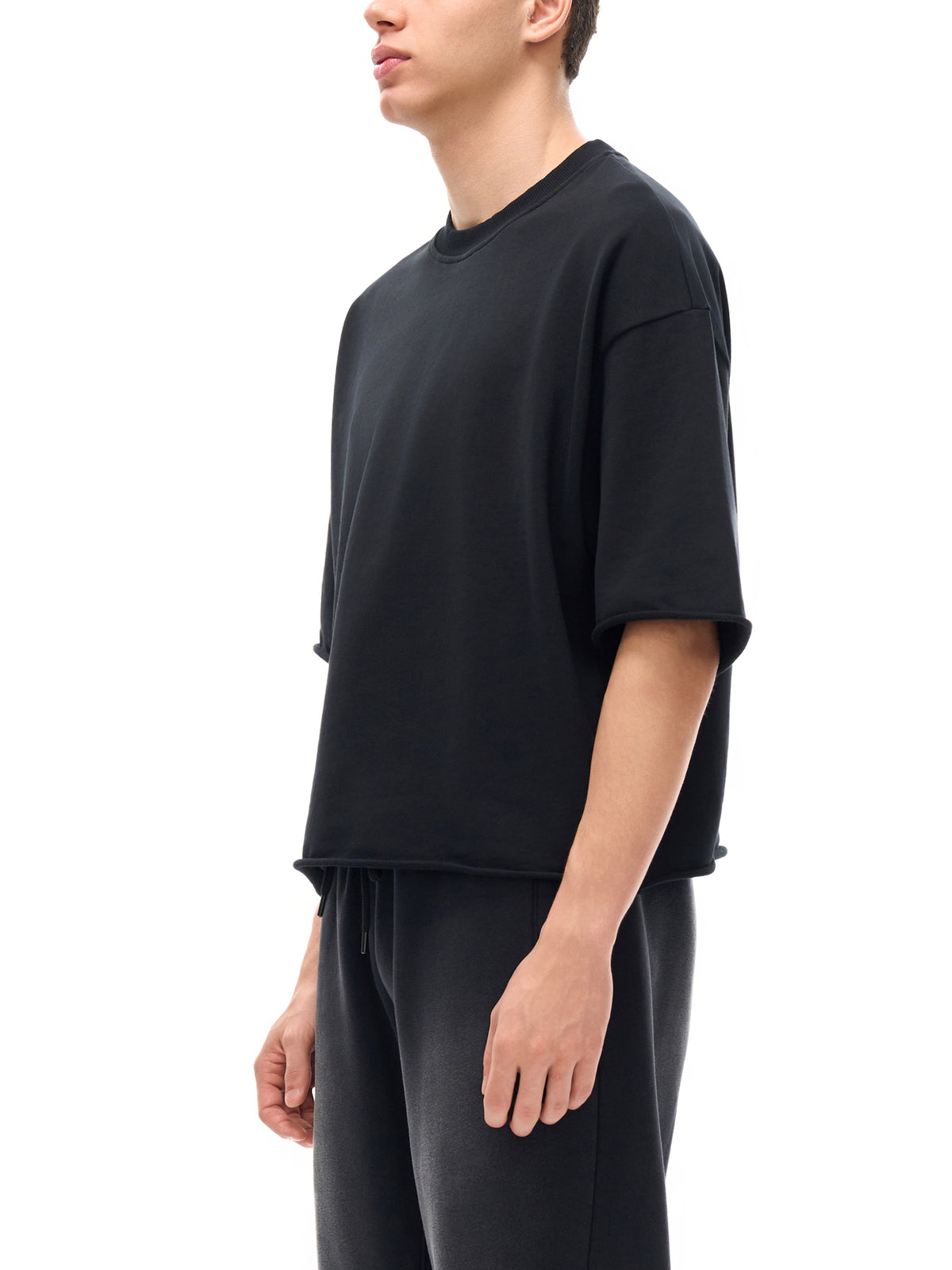 Unisex French Terry Raw-Edge T-Shirt in Black - model side view