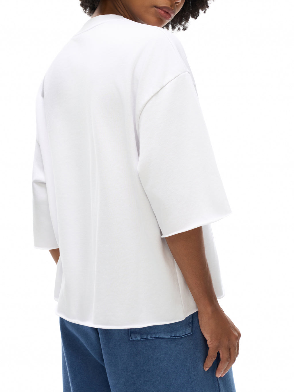 Unisex French Terry Raw-Edge T-Shirt in White - model rear angled view